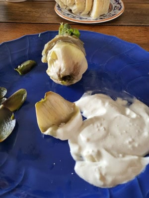Artischockenherz freigelegt - Blaetter mit Aioli auf Teller