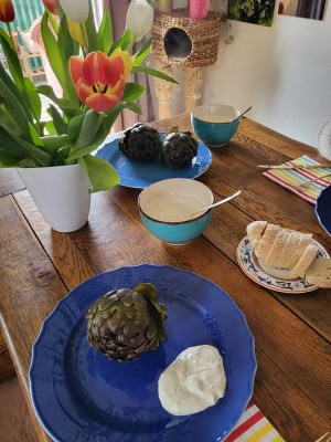 Artischocken serviert auf blauem Teller mit Aioli - gedeckter Tisch