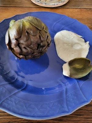 Artischocke auf Teller mit Aioli - Blatt abgezupft zum Dippen